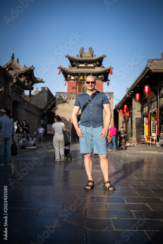 Man posing in front of ancient Chinese architecture in Pingyao