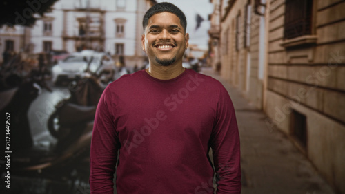 Photos Hispanic man with beard standing facing camera, eyes closed then smiling across frames, wearing maroon shirt on a street; serenity presence