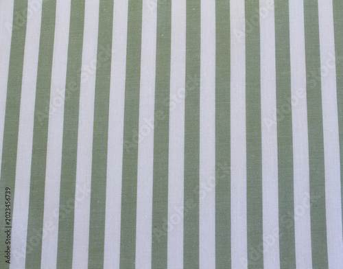 Close up of green and white vertical striped fabric. Texture of classic green striped cotton cloth background.