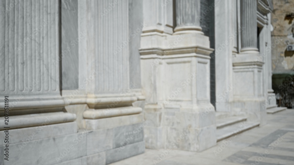 Fototapeta premium Blurred marble facade with classical columns and stepped entrance, defocused church exterior; background backplate copyspace.