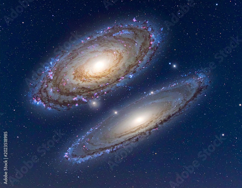 Two galaxies collide in the night sky over a dark background filled with stars and cosmic dust