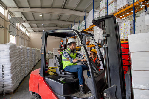 Foto A warehouse worker navigates a forklift through a warehouse, surrounded by stacked pallets and shelves