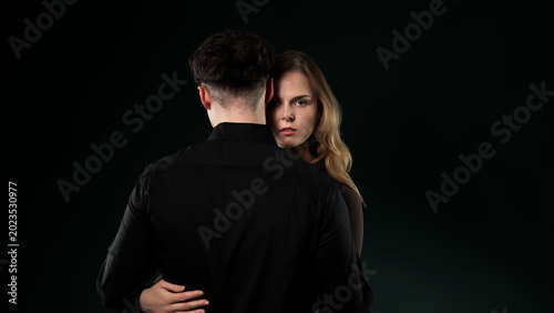 Tableau sur toile Woman looking at camera over man's shoulder representing emotional distance and