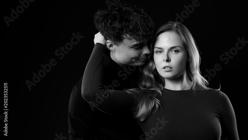 Bild auf Leinwand Young couple embracing, showing intimacy and emotion in a black and white portra