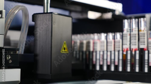 Healthcare. Clinical blood chemistry analyzer at work. Automated process of biological samples research in biochemistry analyzer. Professional lab equipment scanning barcodes on test tubes. 4 k video