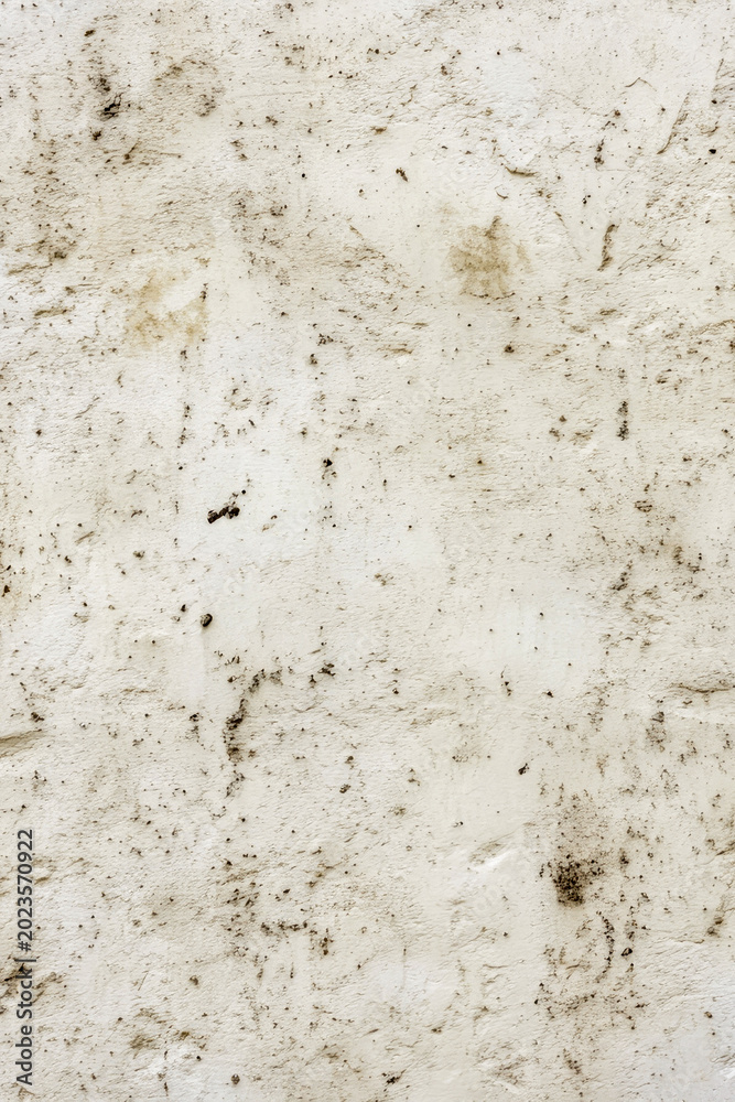 Fototapeta premium Dirt and grime cover a section of white wall, often used in construction or renovation scenes. vertical frame