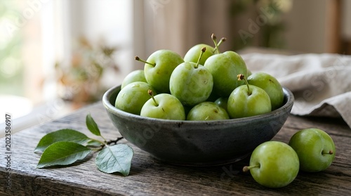 Fresh green plums in a rustic bowl on a wooden table.