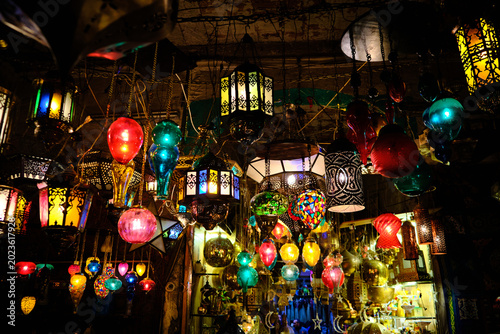Night view of numerous colorful decorative lanterns hanging inside a traditional market or souvenir shop. Lively ambiance of Middle Eastern bazaars and markets. Khan El Khalili market in Cairo, Egypt