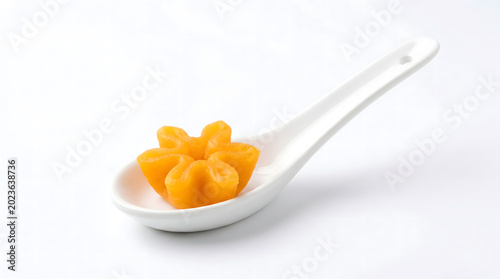 Thong Yip in ceramic spoon isolated on pure white background with clean elegance