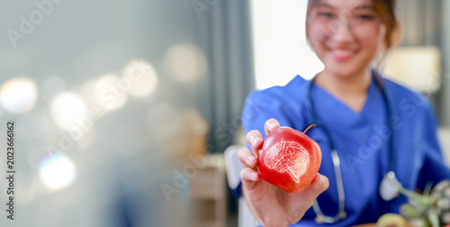 Female nutritionist doctor shows red apple fruit has brain nourishing benefits, inhibits Parkinson's disease, increases and nutritional health benefits : Health care and nutrition concept.