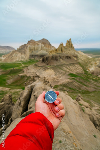 A compass in hand against the backdrop of the Airakty Valley of Castles in Kazakhstan
