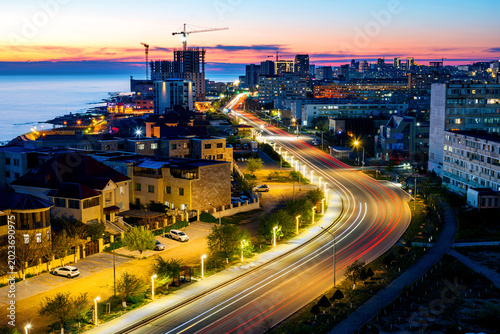 Night traffic in the city, streaks from car headlights at sunset in Aktau