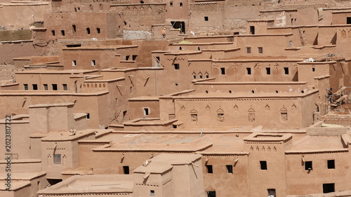 Quadro su tela Traditional adobe village architecture with layered earthen homes in a desert landscape