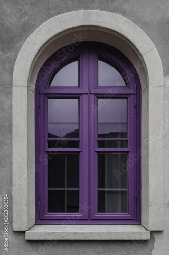 Portrait of purple window on gray wall background 