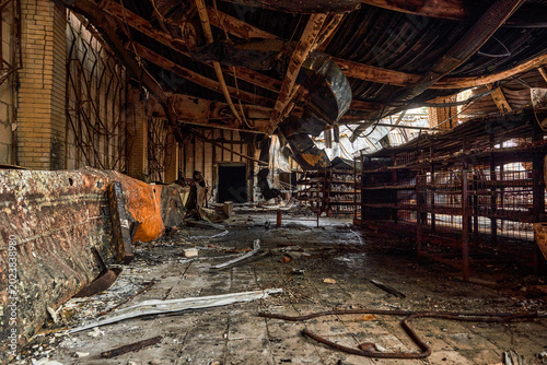 Bild auf Leinwand Destroyed warehouse hallway with fire damage and debris.