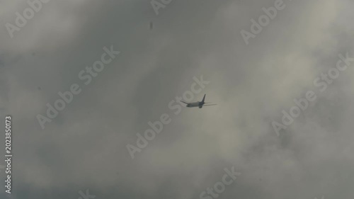 Jet airliner climbing after takeoff and passing through clouds near Singapore airport.