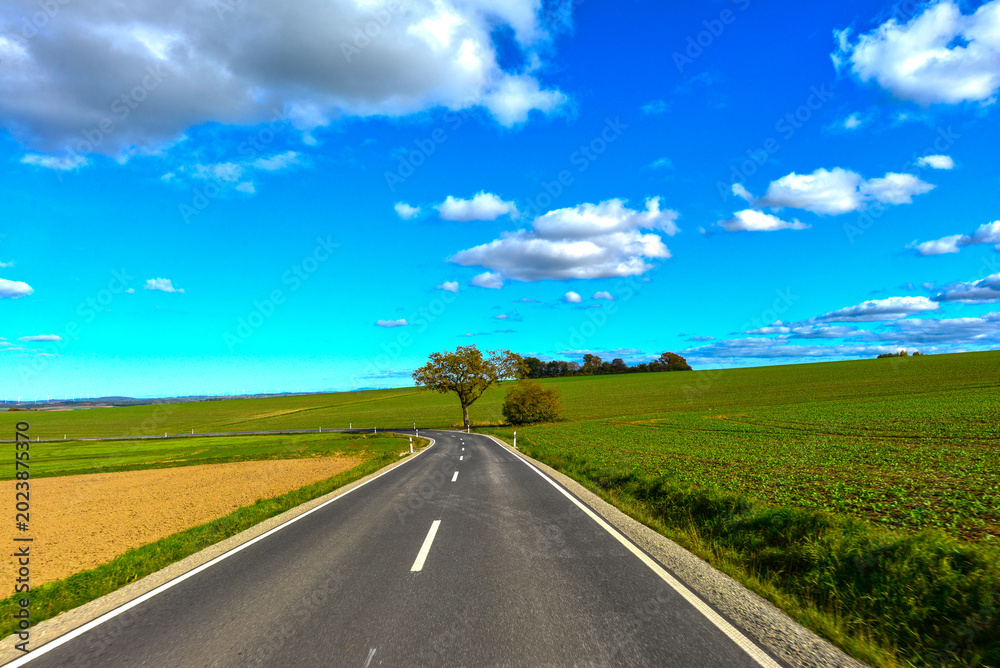 Fototapeta premium Fahrt auf der Landesstraße L3314 durch Felder vor Brachttal-Spielberg im Main-Kinzig-Kreis, Hessen 
