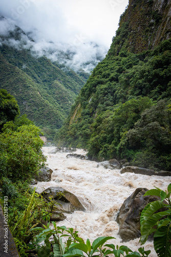 Obraz na płótnie Río caudaloso de aguas turbias entre verdes colinas, selva alta en la Amazonía peruana