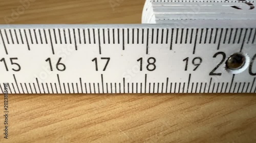 a measuring tape or a folding ruler on wooden background