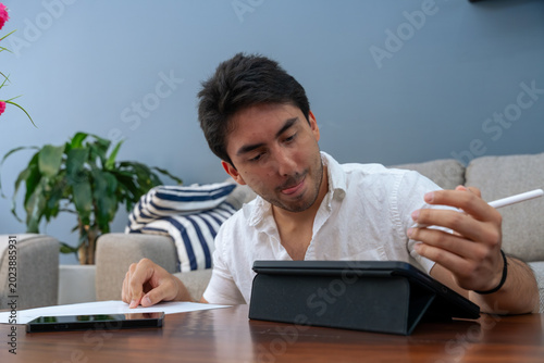 Photos Man concentrating on digital tablet using pen