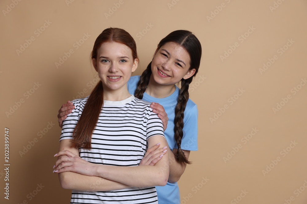 Naklejka premium Portrait of teenage girls on beige background, space for text