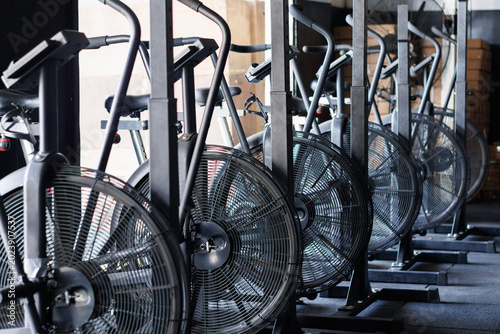 Air bikes lined up in a row at a gym, ready for high intensity interval training and powerful cardio workout sessions
