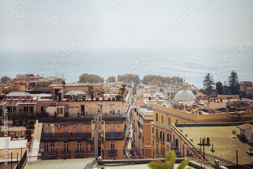 View over historic city rooftops and apartment buildings toward the Mediterranean sea in Naples Italy