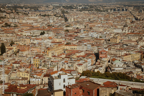 Panoramic view of the old town of Naples, Italy, with historic buildings, rooftops, and the Bay of Naples seen from the Sant'Elmo castle viewpoint