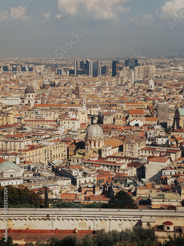 Panoramic view of the old town of Naples, Italy, with historic buildings, rooftops, and the Bay of Naples seen from the Sant'Elmo castle viewpoint