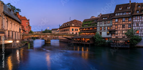 Tableau sur toile Half timbered houses by canals of Petite France in Strasbourg, France at sunset