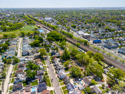 Aerial view of suburbs and residential neighborhood with homes and train tracks, showcasing urban sprawl and community living in long island, new york