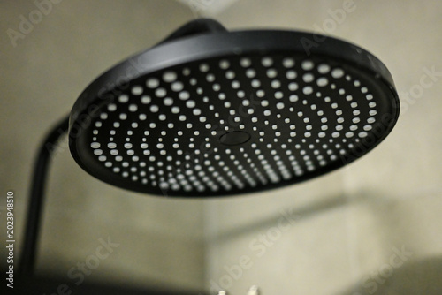 Modern black rain shower head. Luxury round rainfall shower.