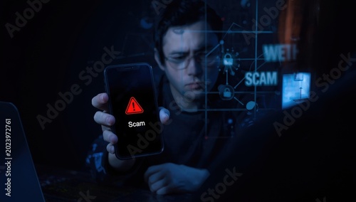 Individual displays a smartphone with a scam alert symbol; phishing email indicates a cyber danger and online fraud risk.
