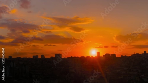 Timelapse: amazing sunset sky with the setting sun and moving clouds over the city of Istanbul in the evening - residential buildings silhouettes, getting darker. Cityscape and time lapse concept
