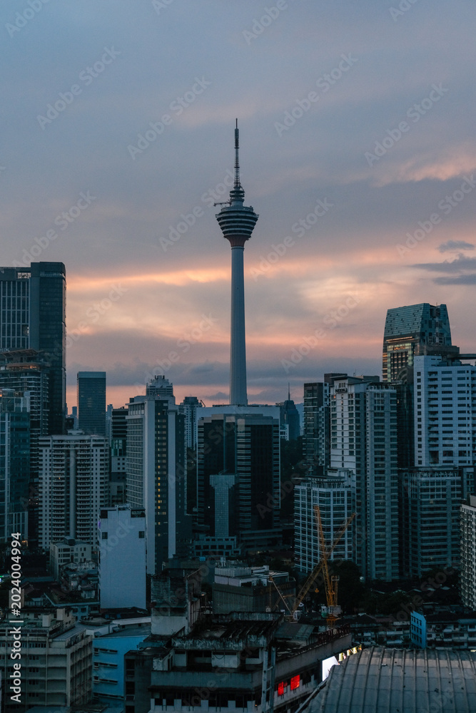 Obraz premium Bukit Bintang cityscape featuring the iconic Kuala Lumpur Tower rising prominently above dense urban skyline, capturing vibrant metropolitan atmosphere and popular tourism district in Malaysia