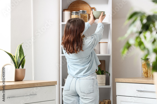 Young woman putting stack o...