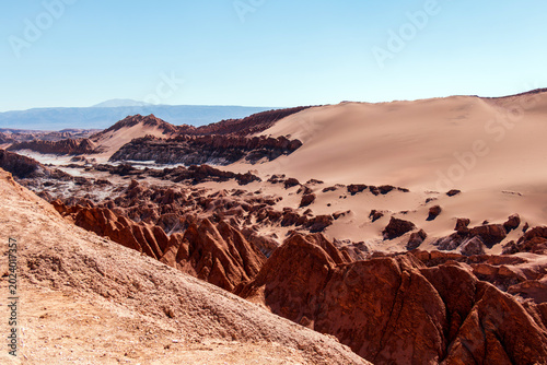 Reddish rock formations and sweeping sand dunes define the dramatic landscape of Moon Valley in Chile’s Atacama Desert