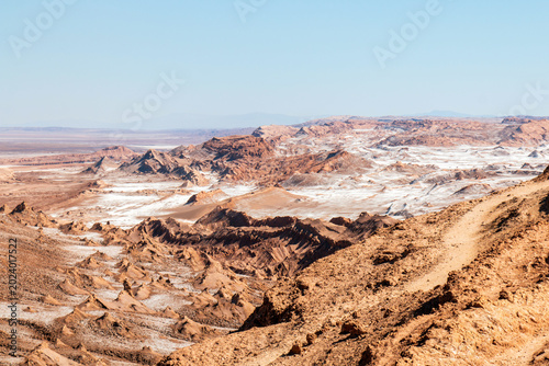 Eroded reddish ridges and scattered white mineral deposits define the dramatic terrain of Moon Valley in Chile’s Atacama Desert
