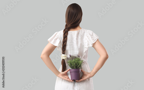 Young woman holding pot wit...