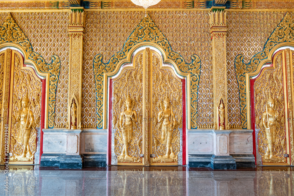 Fototapeta premium High relief guardian figure temple door Prasat Thong Kham Kanchanaphisek golden palace Wat Chantharam, ThaSung UthaiThani Thailand gilded ornament mirrored mosaic.
