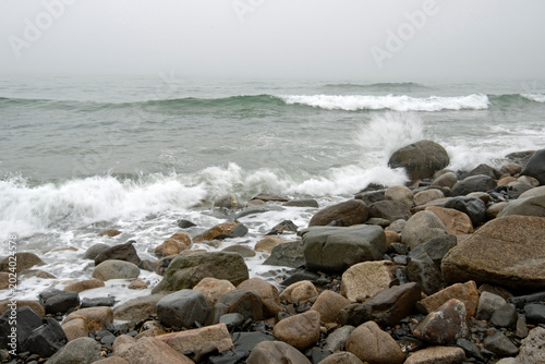 Waves crashing onto the shore on a foggy day