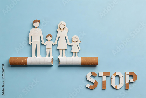 This papercraft artwork shows a family standing on a broken cigarette with a STOP sign made of tobacco pieces, conveying anti-smoking and health protection themes.