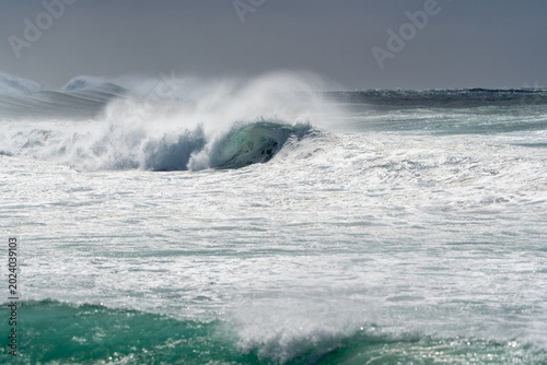 Dramatic ocean waves crashing coastal cliffs during stormy weather