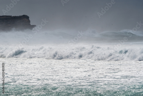 Dramatic ocean waves crashing coastal cliffs during stormy weather
