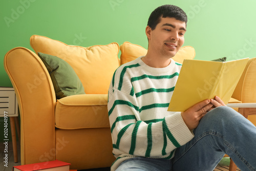 Young man reading book at home