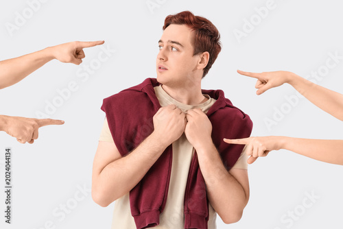 Photos People pointing at young man on white background