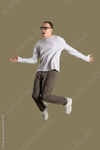 Young man jumping on green ...