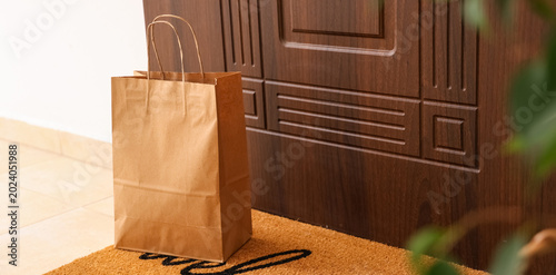 Shopping bag on mat near do...