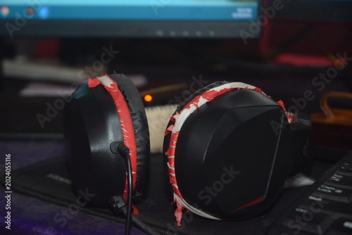 Fényképezés Pair of black gaming headphones with red accents on a keyboard, high fidelity