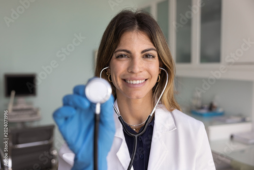 Canvas-taulu Close up head shot portrait of smiling Latina woman cardiologist in uniform show
